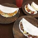 Quatro tapiocas nos pratos da Tapiocaria Nordeste Capixaba disponíveis para escolha no cardápio da empresa.